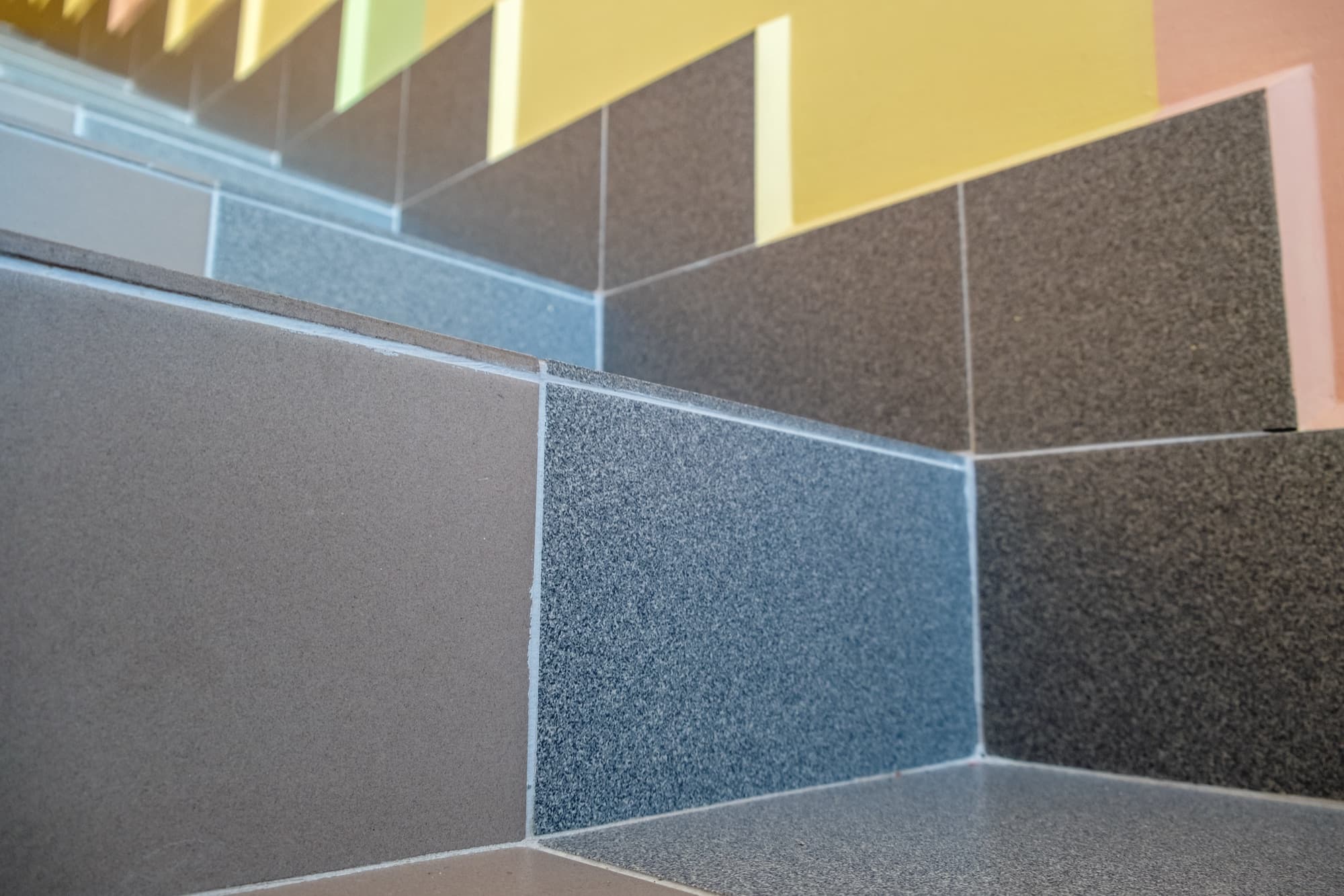 Modern tiled staircase set against a colourfully painted wall