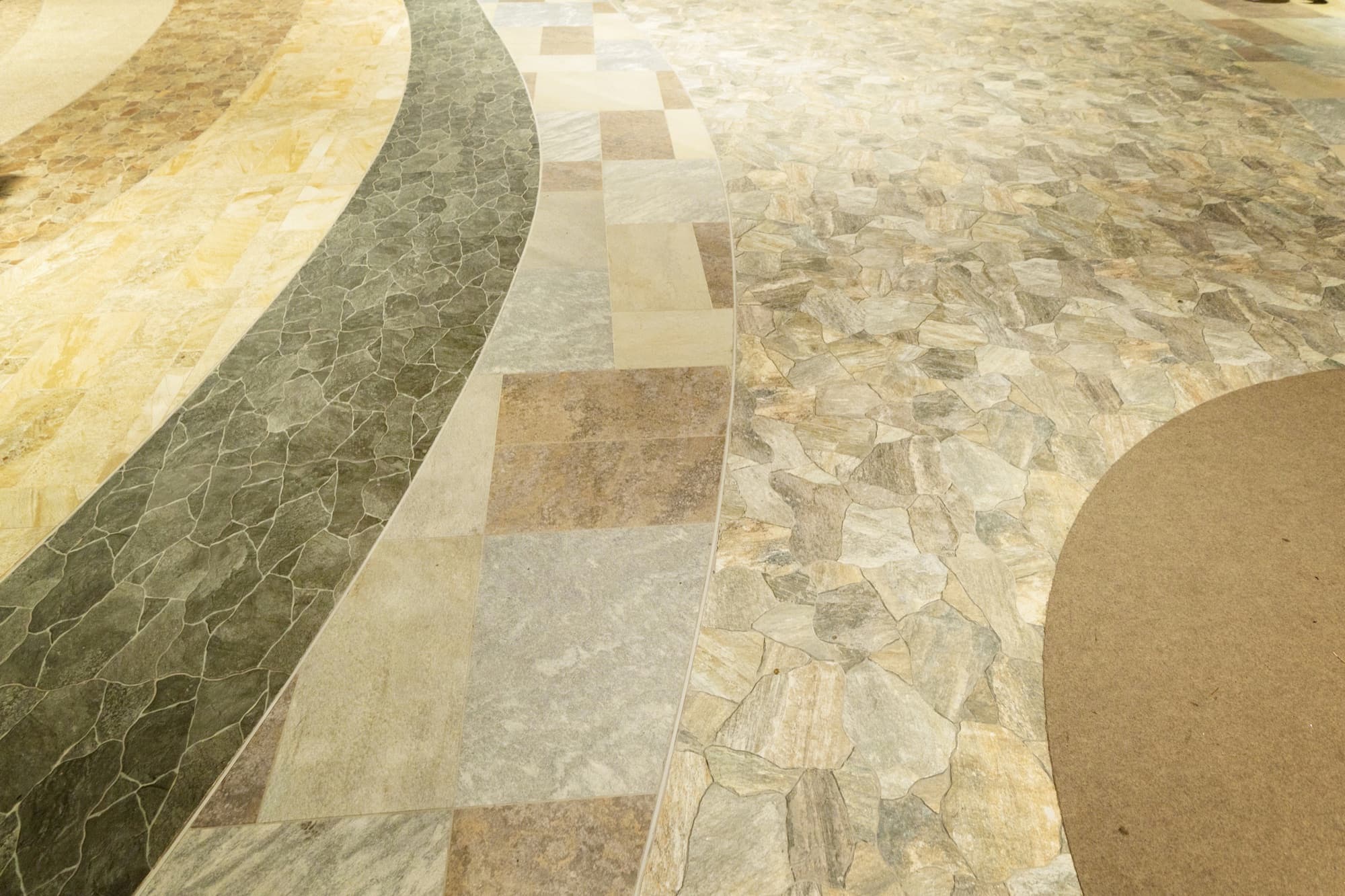 Curved bands of natural stone and tile set into a patterned floor